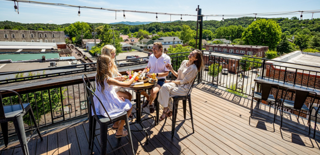 a family enjoying a meal on a rooftop in downtown Ellijay